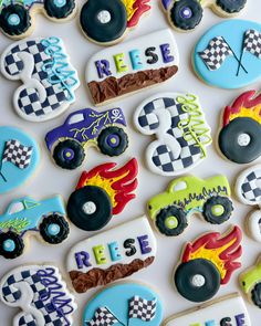 decorated cookies are arranged in the shape of monster trucks and race cars on a white surface