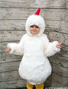 a little boy dressed in a chicken costume posing for the camera with his hands out