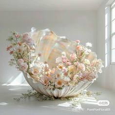 a shell with flowers in it sitting on the floor next to a window sill