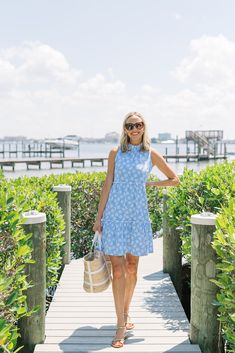 Introducing our vibrant Nicola Dress in the playful and summery Umbrella Sky print! Crafted from a lightweight stretchy cotton knit, this dress is as comfortable as it is stylish, making it the perfect choice for those warm sunny days. The standout feature of this dress is its charming ruffled collar and tiered skirt, adding a flirty and feminine touch to your look. Whether you're strolling along the beach or attending a garden party, this dress will make you feel effortlessly chic and carefree. Printed Cotton Sundress For Vacation, Casual Printed Sundress For Summer Outings, Cotton Beachy Dresses For Summer, Cotton Beachy Dress For Summer Outings, Summer Printed Cotton Mini Dress, Sleeveless Cotton Dresses For Summer Outings, Casual Cotton Mini Dress For Summer Outings, Cotton Beach Season Dresses For Day Out, Summer Beachwear Dress With Upf 50+