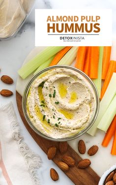 an image of hummus with carrots and celery on a cutting board