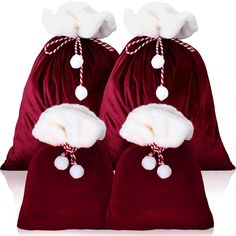 two red velvet bags with white pom - poms on the top and bottom