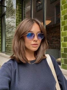 The shoulder-length bob showcased in this image is the epitome of urban sophistication. With its rich, chocolate hue and smooth, rounded edges, this style is ideal for winter hairstyles shoulder length. It's a look that exudes confidence and class, perfect for the modern woman navigating the cityscape. Shoulder Length Haircuts No Bangs, Medium Bob Layers, Shoulder Length Bob For Thick Hair, Short Haircuts For Women Shoulder Length With Curtain Bangs, Brunette Lob With Layers, Clavicle Length Hair Straight, Above The Collar Bone Haircut, 90sbob Haircut, Over Shoulder Length Hair