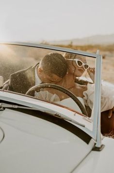 a man and woman kissing in the back of a car