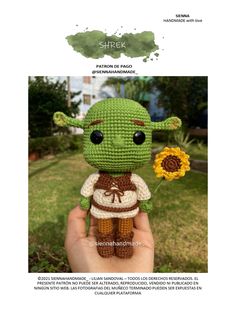 a crocheted yoda doll holding a sunflower in it's hand