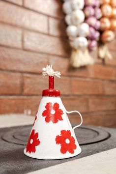 a red and white flowered cone sitting on top of a stove