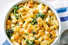 a bowl filled with pasta and broccoli on top of a blue and white towel