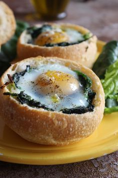 eggs in bread with spinach leaves on a yellow plate