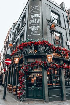 the exterior of a building decorated for christmas with wreaths and garland on it's windows