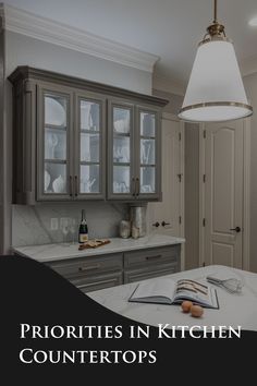 a kitchen with gray cabinets and an open book on the counter in front of it