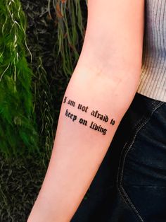 a person with a tattoo on their arm that says i am not afraid to keep on living