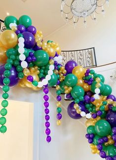 a bunch of balloons hanging from the ceiling in a room with stairs and chandelier