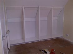 an empty room with white closets and construction tools on the floor next to it