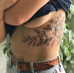 a woman with a flower tattoo on her stomach