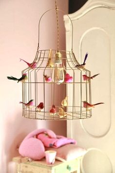 a birdcage filled with birds sitting on top of a table next to a teddy bear