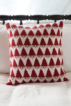 a red and white pillow sitting on top of a bed