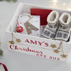 a christmas eve box filled with baby's shoes and gifts