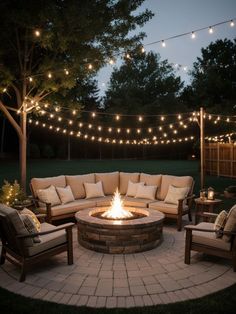 a fire pit surrounded by patio furniture and string lights in the backyard at night time