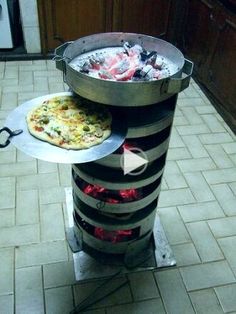 a pizza sitting on top of a stove next to a metal pan filled with food