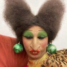 a woman with green makeup and afro hair