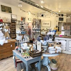 a room filled with lots of furniture and items on display in front of a window