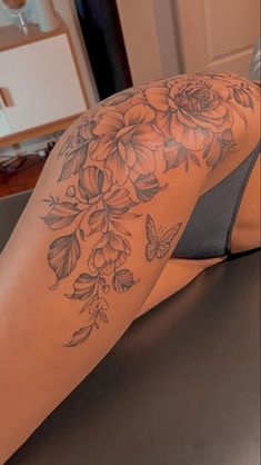 a woman's leg with flowers and butterflies on it