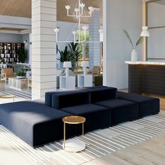 a living room filled with furniture and a chandelier hanging from the ceiling above it