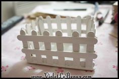 a small white fence sitting on top of a table