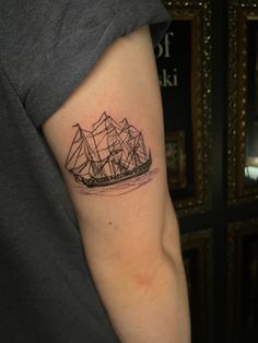 a small ship tattoo on the left arm