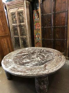 an old table sitting in front of some wooden doors