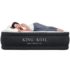 a woman laying on top of a king koil mattress in the shape of a bed