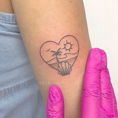 a woman's arm with a heart shaped tattoo on the left side of her arm