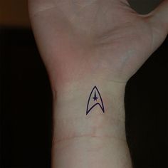 a small star trek tattoo on the wrist