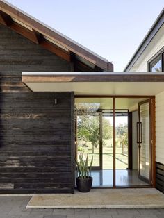 an entrance to a modern house with wood siding