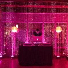 a man sitting in front of a laptop computer on top of a table covered in lights