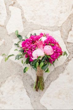 a bouquet of pink flowers sitting on top of a stone floor