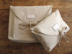 an envelope is wrapped in linen and tied up with a tag on the front, sitting on a wooden floor