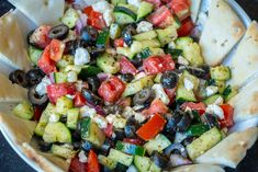 a bowl filled with vegetables and pita bread