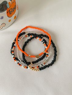 Mommy and Littles Co Spooky Halloween beaded bracelet set of 5. DETAILS: *3mm and 4mm glass seed beads. *4mm 14k gold plated beads and heart. *Made with jewelry quality elastic string.  *please message FIRST if you are needing a size that is note listed.  **NOTE: this listing is for all FIVE bracelets pictured. Halloween Seed Bead Bracelet, Fall Beaded Jewelry, Fall Beaded Bracelets, Halloween Bracelet Diy, Bracelets Halloween, Fall Bracelets, Everyday Bracelets, Halloween Jewelry Diy, Halloween Beaded Jewelry