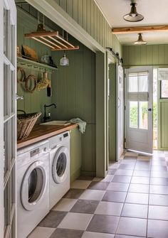 a washer and dryer are in the middle of a room with green walls