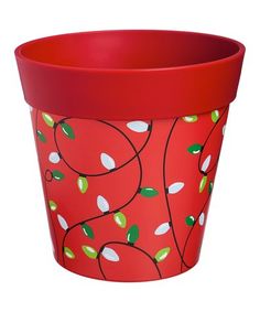 a red flower pot with leaves painted on the outside and inside, sitting in front of a white background