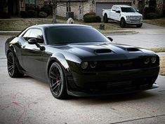 a black sports car parked in front of a house