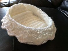 a white crocheted basket sitting on top of a black leather couch