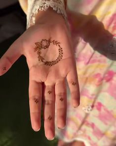 a woman's hand with a henna tattoo on her left palm and fingers