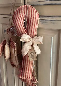 an old door hanger is decorated with red and white striped fabric