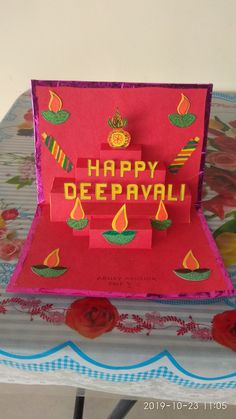 a card with the words happy deepavai written on it and lit candles inside