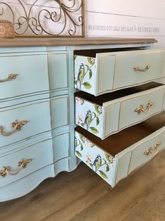 the drawers are painted blue and have birds on them