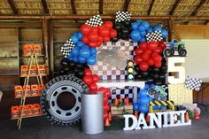 balloons and race cars are on display in a garage