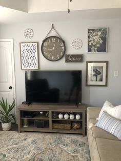 a flat screen tv sitting on top of a wooden entertainment center in a living room