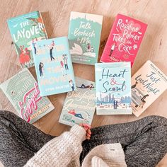 a person laying on the floor with many books in front of their face and feet